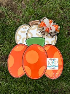 three orange plates sitting on top of green grass next to each other and a bow