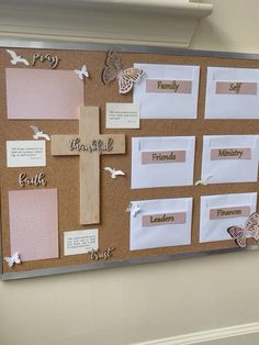 a bulletin board with paper and magnets attached to it, all decorated in pink and white