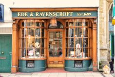 a store front with two large windows on the outside and green doors that say ede & ravennscottt es ltd