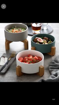 three bowls with food in them sitting on a table