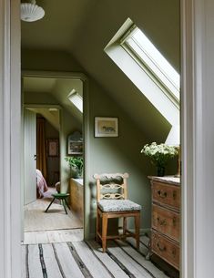 an attic bedroom with green walls and white trim