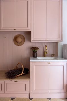 a kitchen with pink cabinets and a white sink in the center, along with a basket on the counter