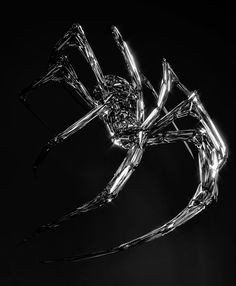 a metal spider sculpture is shown against a black background