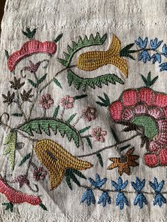 an embroidered cloth with flowers and birds on it