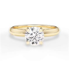 a yellow gold engagement ring with a round brilliant diamond in the center, on a white background