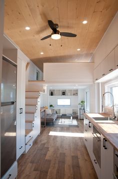 the inside of a house with wood floors and ceiling fans