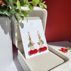 Indulge in the sweet charm of these delightful cherry drop dangle earrings! The vibrant red hue captures the essence of ripe cherries, making these earrings a true delight for the senses. These earrings will sway gracefully with every movement, drawing admiring glances wherever you go.  🍒Material: The earrings are made with red or wine glass cherries, acrylic flowers, acrylic leaves and the 14K gold-plated(hypoallergenic) earring findings. Handmade in Maryland! 🌺 Size: The huggie style is about 1.2cm x 3cm. The hook style is about 1.2cm x 3.5cm. 🎀Handmade: Each item is made to order, which gives our pieces a unique meaning that is specific and special to you. Therefore, there are no two items exactly alike. This product contains small parts. Use caution when giving to young children les Cherry Colored Earrings Gift, Cherry Colored Drop Earrings With Ear Wire, Cherry Dangle Earrings With Ear Wire, Cherry Color Dangle Earrings, Cherry Drop Earrings With Ear Wire, Cherry Colored Earrings For Valentine's Day Gift, Cherry Earrings For Valentine's Day Gift, Cherry Color Earrings For Valentine's Day Gift, Red Cherry Print Jewelry For Gifts