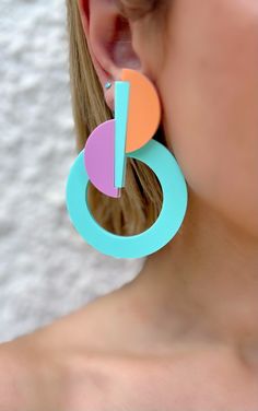 a close up of a person wearing large earrings with circles on the front and back of them