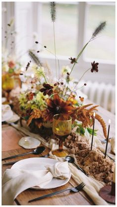 the table is set with flowers, candles and other things to decorate it for dinner