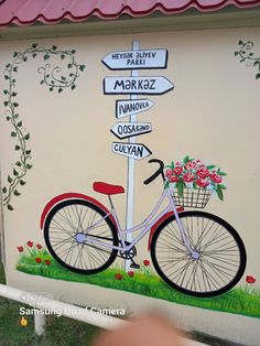 a bicycle parked next to a street sign with flowers on it and the name markaz