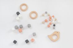 various wooden toys are arranged on a white surface, including beads and ring shapes that appear to be made out of wood