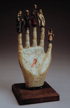 a hand with five small figurines on it's thumb and fingers in the middle