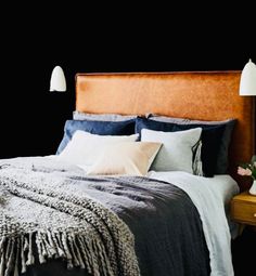 a bedroom with black walls and white lamps