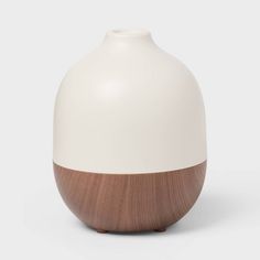 a white and brown vase sitting on top of a table