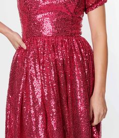 This dazzling dress is perfect for those who want to turn heads and make a statement. The hot pink sequins shimmer and shine, ensuring that you'll be the center of attention wherever you go. With its fit & flare silhouette, this dress is designed to flatter all body types by cinching at the waist and flowing out into a twirl-worthy skirt. The woven fabric feels luxurious against your skin, while the back zipper ensures an easy and seamless fit. Short sleeves with elastic cuffs add a touch of pla Glamorous Sequin Prom Dress For Festive Occasions, Festive Sequin Prom Dress, Glamorous Sparkling Sequin Fabric For Homecoming, Festive Glamorous Glitter Sequin Dress, Holiday Sequin Dress With Contrast Sequins For Festive Occasion, Pink Sequin Dress With Fitted Bodice, Sparkling Sequin Dress For Homecoming Party, Sparkling Sequin Dress For Homecoming Party Season, Fitted Shimmer Dress For Festive Season