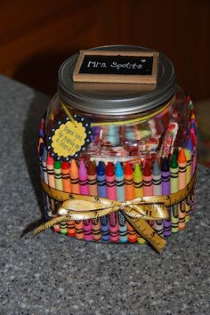 a jar filled with lots of crayons on top of a table