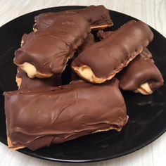 chocolate covered pastries on a black plate