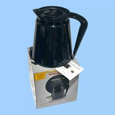 a black coffee pot sitting on top of a box with a price tag attached to it