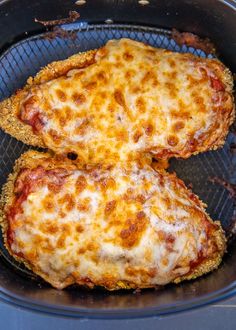 two cheesy pizzas sitting in an air fryer