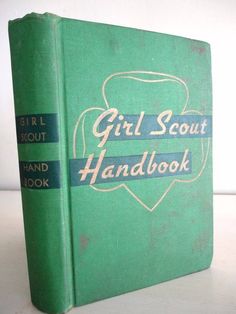 a green book with the title girl scout's handbook written in blue on it