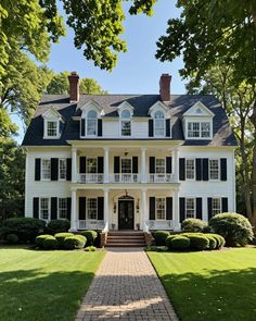 a large white house sitting on top of a lush green field