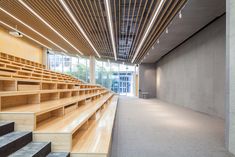 an empty auditorium with wooden steps leading up to the second floor and windows on both sides