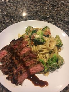 steak, broccoli and noodles on a white plate