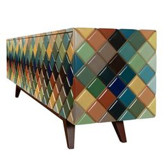 an upholstered cabinet with multicolored tiles on it