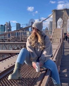 a woman sitting on top of a bridge