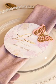 a plate with a pink napkin and butterfly on it