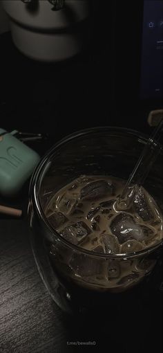 a bowl filled with liquid sitting on top of a table next to a remote control