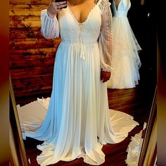 a woman taking a selfie in front of a mirror wearing a wedding dress and holding a cell phone