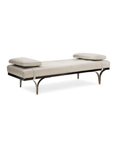 a modern daybed with two pillows on it's back and one seat upholstered to the side