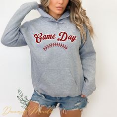 This super soft and cozy Game Day unisex hoodie is perfect for baseball fans on game days!  Everyone needs a cozy go-to hoodie to curl up in, so go for one that's soft, smooth, and stylish. It's the perfect choice for cooler evenings! * 50% pre-shrunk cotton, 50% polyester * Fabric weight: 8.0 oz/yd² (271.25 g/m²) * Air-jet spun yarn with a soft feel and reduced pilling * Double-lined hood with matching drawcord * Quarter-turned body to avoid crease down the middle * 1 × 1 athletic rib-knit cuff Tball Mom, Busy Raising Ballers, Raising Ballers, Baseball Mom Gifts, Baseball Sweatshirts, Quick Coffee, Baseball Hoodie, Baseball Mama, Mom Hoodies