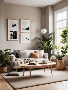 a living room filled with furniture and potted plants on top of a wooden floor