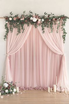 a pink backdrop with roses and greenery on it for a wedding ceremony or reception