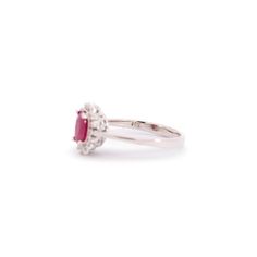 a white gold ring with an oval shaped ruby stone in the center and diamond accents