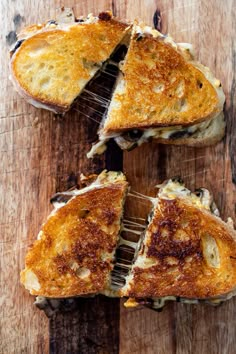 grilled cheese sandwiches cut in half on a wooden table