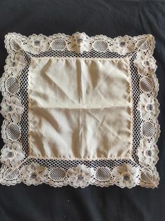 an old lace doily on a black cloth