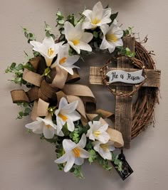 a wreath with flowers and a cross hanging on the wall