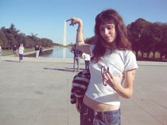 a young woman poses for a photo in front of the lincoln memorial with her arm raised