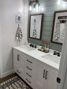 a bathroom with two sinks, mirrors and lights on the wall above them is decorated in black and white