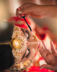 a woman getting her make up done by a professional makeup artist at a bridal event