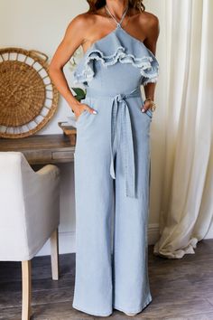 Get ready to make a statement at your next party with the Cillian denim jumpsuit! This playful halter hem is both flirty and fun, perfect for standing out in the crowd. Step out in style and turn heads with this unique and quirky jumpsuit.e 75% Cotton 22% Polyester 2% Viscose 1% Spandex Color: Light Denim Halter Denim Jumpsuit Tie Halter Detail Bust Frayed Hem Wide Leg Denim Back Zipper Closure Functional Pockets Front Tie waist band True to size Model is wearing the size Small. She is 5'6". 135 Bottom Workout, Dressy Tops, Denim Jumpsuit, Outerwear Sweater, Dressy Casual, Wide Leg Denim, Light Denim, Swimwear Accessories, Spring Collection