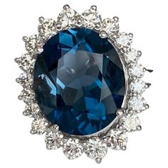 Offered: 18-kt handmade white gold women's ring with an oval facet cut Blue London Topaz of 7.00 ct. surrounded by 20 brilliant cut diamonds, approx. 1.20 ct, of quality E/F/VVS/VS. ALGT certificate is included. Grade: 750 (marked) Natural Blue London Topaz - approx. 7.00 ct (treatment is unknown) Natural diamonds - approx. 1.20 ct E/F/VVS/VS Ring head size: 21 mm x 20 mm Weight: 8.24 grams Ring size: 17.50 mm (can be resized) Comes in a ring box London Topaz, Diamond Cocktail Ring, Diamond Cocktail Rings, Cocktail Ring, Ring Box, Brilliant Cut Diamond, Cocktail Rings, Women Rings, Natural Diamonds