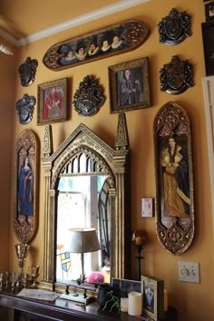 an ornate mirror is on the wall above a table with candles and other decorative items