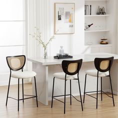 three chairs are sitting at a white table