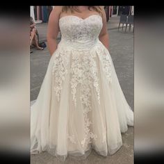 a woman in a wedding dress standing on the street