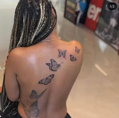 the back of a woman's body with butterflies on her left shoulder and right arm