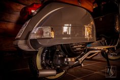 the front end of a motorcycle parked in a garage next to a wall with lights on it